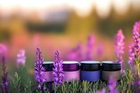 Natural cosmetic jars in lavender field at sunset. Organic skincare products among purple flowers. Spa wellness beauty treatment concept for aromatherapy.