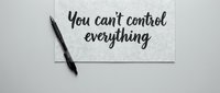 Motivational quote card with black pen on white surface reads you cant control everything for mindfulness and personal development concepts.