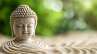 Stone Buddha statue in meditation pose on zen garden sand with peaceful green bokeh background for mindfulness and spiritual wellness practices.
