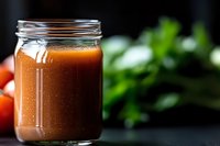Fresh homemade tomato juice or vegetable smoothie in glass mason jar on dark background with herbs and ingredients, healthy drink concept.