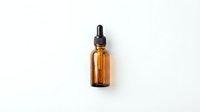 Amber glass dropper bottle with black rubber bulb and pipette on white background isolated for skincare cosmetic and essential oil packaging design.