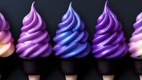 Colorful soft serve ice cream swirls in pink, purple and blue tones arranged in row on dark background. Creamy frozen dessert with smooth texture and gradient colors.