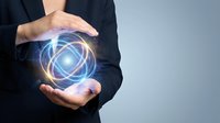 Business professional holding glowing energy sphere with geometric patterns representing innovation, technology solutions and digital transformation concepts.