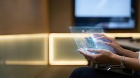 Businesswoman using transparent holographic tablet with digital interface in modern office environment for futuristic technology presentations.