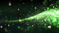 Magical green glowing particles flow in dark space creating ethereal light trail effect with bokeh circles and sparkles against black background.