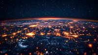 Aerial view of Earth at night showing glowing city lights and interconnected networks across curved horizon against starry space background. Global connectivity concept.