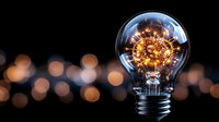 Light bulb with glowing filament and bokeh lights on dark background symbolizing creativity innovation and bright ideas for business concepts.