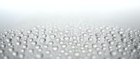 Water droplets scattered on clean white surface creating natural moisture pattern with soft focus background for fresh concepts.