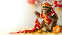 Adorable monkey in traditional Chinese costume celebrating lunar new year with festive decorations and golden coins for holiday greeting cards.