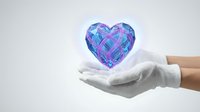 Hands in white gloves holding glowing crystal heart with geometric faceted design on light background for healthcare and love concepts.