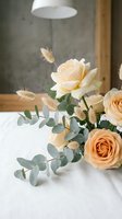 Elegant peach roses with eucalyptus and dried pampas grass arranged on white table in modern interior for wedding decor and romantic celebrations.