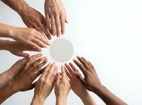 Multiple diverse hands arranged in circle around blank white space, symbolizing unity, teamwork, collaboration, and community support for business or nonprofit concepts.