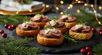 Festive holiday appetizers with beef tenderloin on toasted bread garnished with herbs and cranberries, perfect for Christmas entertaining and celebrations.