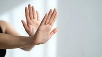 Two hands raised in stop gesture showing palms forward against white background for communication and body language concepts.