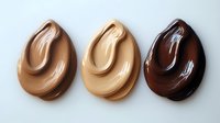 Swirled drops of liquid foundation makeup in different skin tone shades from light to dark on white background, isolated cosmetic texture for beauty industry.