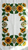Traditional Ukrainian embroidered sunflower pattern on white linen fabric with colorful cross-stitch geometric ornaments for cultural textile design.