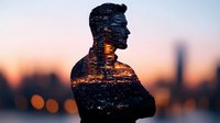 Male silhouette double exposure with urban night cityscape, bokeh lights and sunset sky creating atmospheric mood for conceptual design and storytelling.
