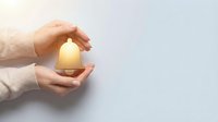 Protective hands cupping glowing house symbol representing home insurance, real estate security, property protection and mortgage safety concept.