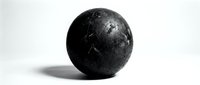 Weathered black sphere with textured surface and shadow on white background, suitable for design projects and creative compositions.