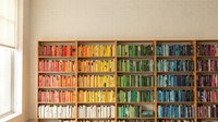 Rainbow organized bookshelf with colorful books arranged by hue creating vibrant home library display for interior design and organization concepts.