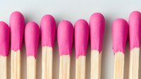Pink lipsticks with golden tubes arranged in row on white background. Cosmetic makeup products for beauty and fashion industry isolated.