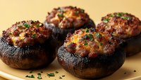 Stuffed portobello mushrooms with cheese and herbs baked to golden perfection, garnished with fresh parsley on warm background for culinary content.