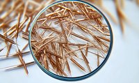 Microscopic view of copper needle-like crystals forming intricate patterns under magnification lens, scientific research background for chemistry and materials study.