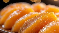Fresh orange mandarin or tangerine slices arranged in row with water drops and bokeh lights, macro close up view on dark background. Juicy citrus fruit.