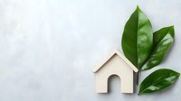 Wooden house shape with fresh green leaves on light background symbolizing eco-friendly living, sustainable housing, and environmental conservation concept.