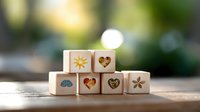 Wooden dice with nature symbols and hearts arranged on rustic wooden surface against soft bokeh background, creating peaceful mindful atmosphere.