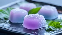 Purple gradient jelly desserts with crystalline sugar sprinkles served on black plate with fresh mint leaves, showcasing modern Asian culinary presentation.