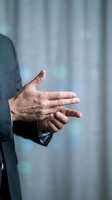 Professional businessman hands demonstrating presentation gesture in modern office environment for corporate communication and business meetings.