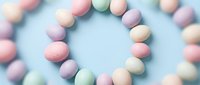 Colorful pastel Easter eggs arranged in circular pattern on soft blue background for spring holiday celebrations and seasonal decorating projects.