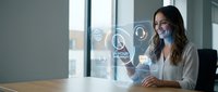 Young professional woman using futuristic holographic interface technology in modern office workspace for business innovation and digital transformation.