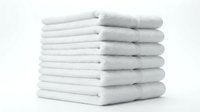 Stack of fresh white fluffy towels neatly folded and piled on white background, isolated for spa, hotel, bathroom and laundry concepts.