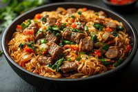 Stir-fried noodles with tender beef chunks, colorful bell peppers, green onions and carrots in savory Asian sauce served in black bowl on dark background.