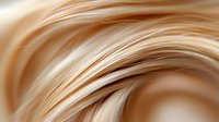 Flowing blonde hair strands with smooth texture and natural highlights creating dynamic movement and shine for beauty and haircare concepts.