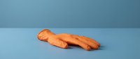 Oddly shaped carrot with human-like form lying on blue surface, quirky vegetable produce for creative food photography and humorous culinary content.
