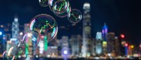 Soap bubbles floating over blurred city lights at night creating magical urban atmosphere with colorful reflections and bokeh effects.