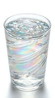 Glass of clear water with ice cubes and iridescent light reflections, isolated on white background for beverage, hydration, and wellness design projects.