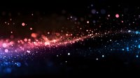 Magical glowing particles with pink and blue bokeh lights floating on black background, creating ethereal cosmic atmosphere for festive designs and celebrations.