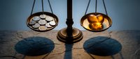 Vintage brass balance scale with ornate decorative plates casting dramatic shadows on textured surface in warm atmospheric lighting for legal concepts.