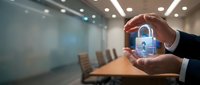 Businessman holding digital padlock hologram in modern conference room, representing cybersecurity, data protection, and secure business solutions for corporate environments.