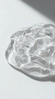 Clear gel or transparent cosmetic product with ice cubes in glass container against white background, isolated for skincare, beauty, and cosmetics design use.