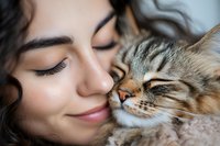Young Hispanic woman with closed eyes and gentle smile nuzzling with sleepy tabby cat in tender moment showing pet companionship and emotional bond.