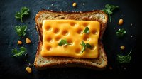 Grilled cheese sandwich with melted yellow cheese slice and fresh parsley leaves on dark stone background, scattered pine nuts around, macro food photography.