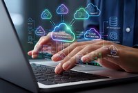 Business professional using laptop with cloud computing technology icons and data management symbols floating above keyboard for digital transformation.