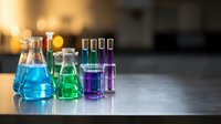Laboratory glassware with colorful chemical solutions on table in modern research facility for scientific experiments and analysis.