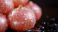 Fresh shallots covered in water droplets on dark background, macro photography with selective focus creating artistic culinary composition.