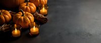 Autumn harvest display with orange pumpkins, glowing candles and pine cones on dark surface creating warm seasonal atmosphere for fall decorating.